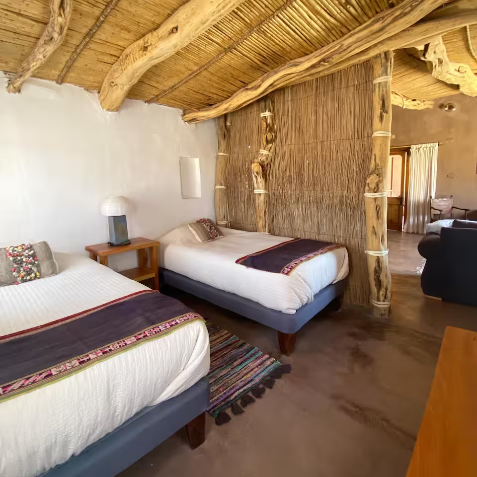 Rustic adobe bedroom at Casa Yali with reed ceiling and woven textiles