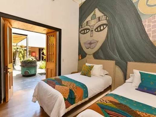A Solar Madariaga room with mural wall and colorful textiles