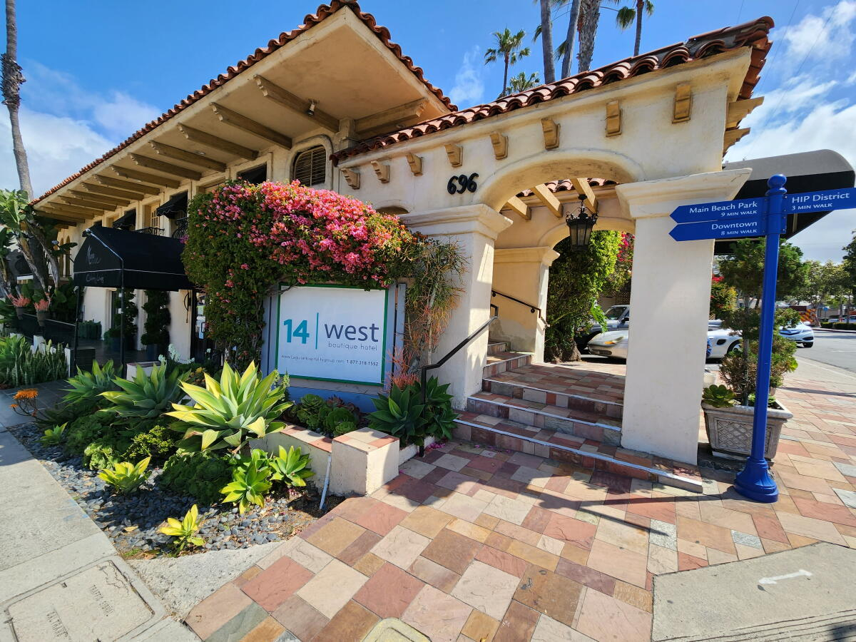 Hotel Boutique Barrio 14 entrance at 696 West Broadway, with Spanish tile roof, arched doorway, bougainvillea and succulents under a blue sky